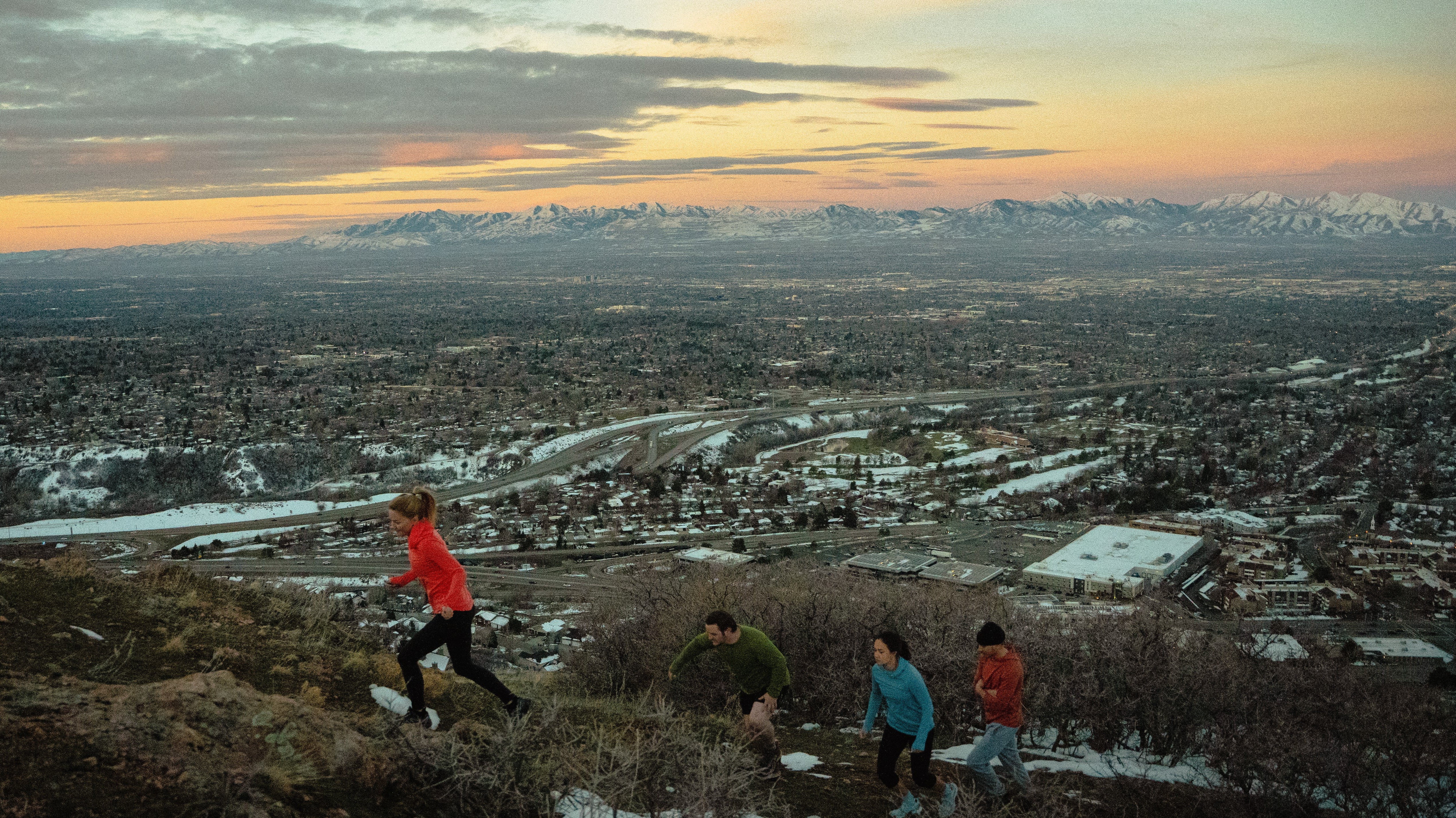4 People running over sunrise on Salt Lake City